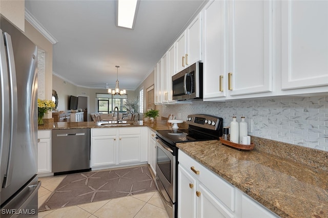 kitchen with sink, white cabinetry, dark stone counters, stainless steel appliances, and decorative backsplash