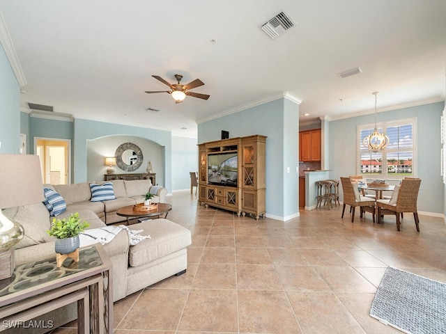 living area featuring light tile patterned floors, ceiling fan, visible vents, baseboards, and crown molding