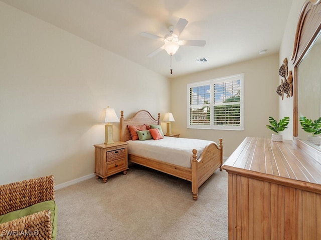 bedroom with baseboards, visible vents, a ceiling fan, and light colored carpet