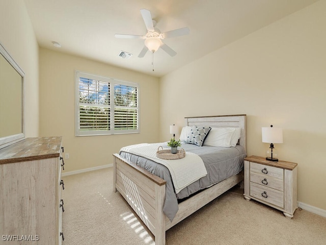 bedroom featuring baseboards, visible vents, a ceiling fan, and light colored carpet