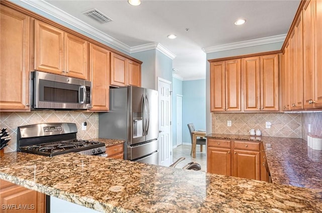 kitchen with stainless steel appliances, a peninsula, visible vents, dark stone countertops, and crown molding