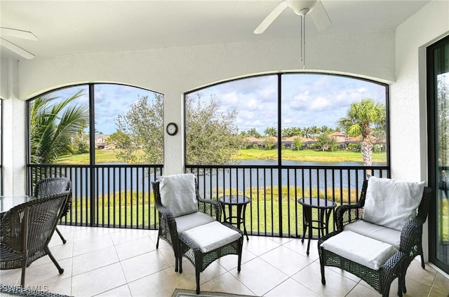 sunroom featuring a water view and ceiling fan