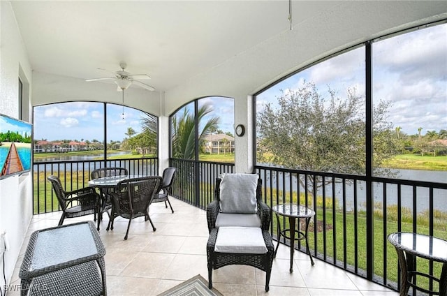 sunroom / solarium with a water view and ceiling fan