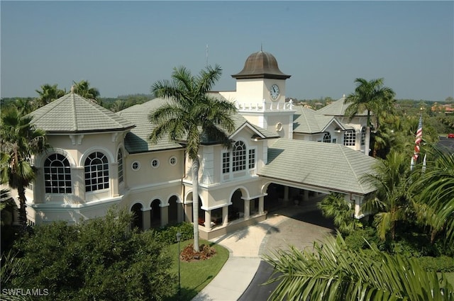 back of house with a tiled roof and decorative driveway