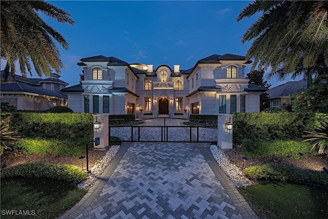 233 Mermaids Bight, Naples, FL 34103 - view of front facade featuring a balcony, a fenced front yard, and a gate