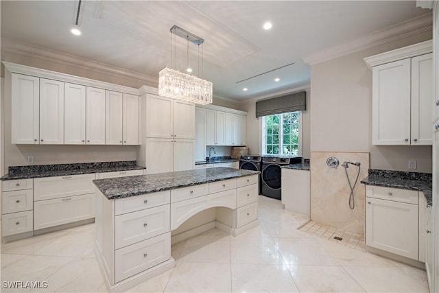 233 Mermaids Bight, Naples, FL 34103 - kitchen featuring crown molding, separate washer and dryer, a kitchen island, and dark stone counters