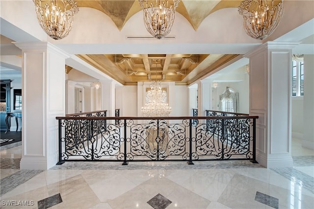 233 Mermaids Bight, Naples, FL 34103 - corridor with coffered ceiling, ornamental molding, decorative columns, a decorative wall, and a notable chandelier