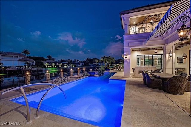 233 Mermaids Bight, Naples, FL 34103 - pool at night featuring outdoor dining area, a patio area, a fenced in pool, a ceiling fan, and fence