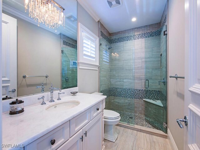 233 Mermaids Bight, Naples, FL 34103 - bathroom featuring a chandelier, vanity, toilet, a stall shower, and ornamental molding