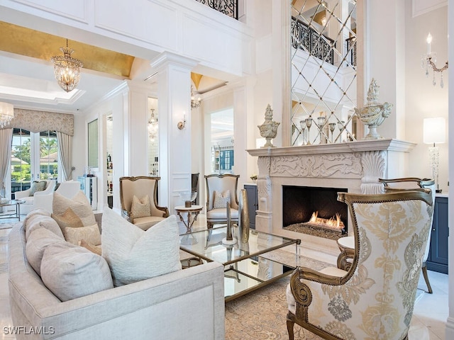 233 Mermaids Bight, Naples, FL 34103 - living room featuring ornamental molding, a high ceiling, an inviting chandelier, and a fireplace