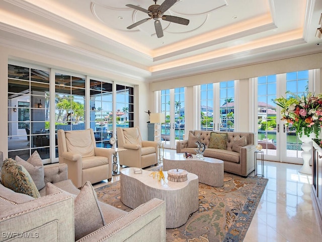 233 Mermaids Bight, Naples, FL 34103 - living room featuring light tile patterned floors, ornamental molding, ceiling fan, a raised ceiling, and french doors