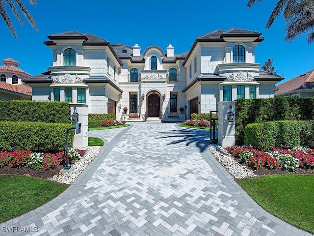 233 Mermaids Bight, Naples, FL 34103 - view of front facade featuring decorative driveway and a chimney