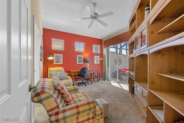 living area featuring light carpet and a ceiling fan