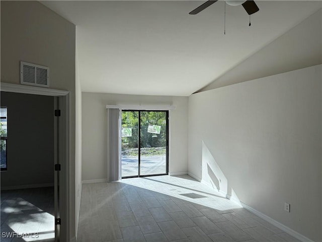 empty room with lofted ceiling, baseboards, visible vents, and a ceiling fan