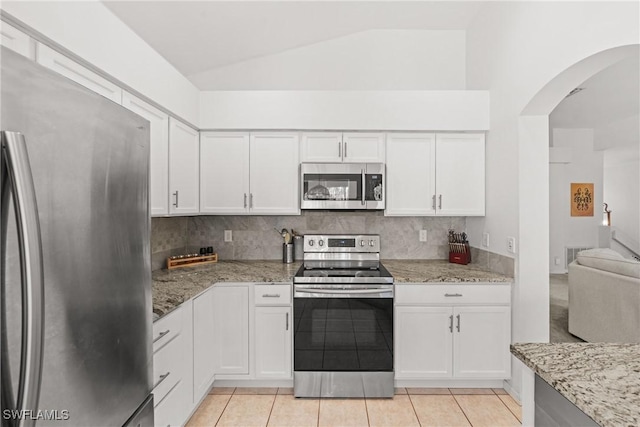 23039 Lone Oak Dr, Estero, FL 33928 - kitchen with stainless steel appliances, decorative backsplash, light stone countertops, and white cabinets