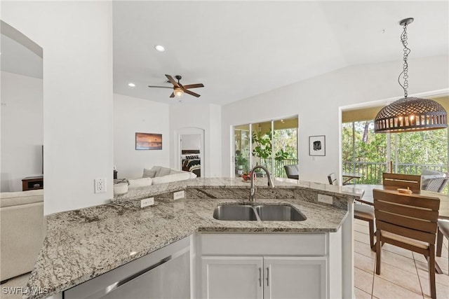 23039 Lone Oak Dr, Estero, FL 33928 - kitchen featuring a sink, white cabinets, open floor plan, stainless steel dishwasher, and decorative light fixtures