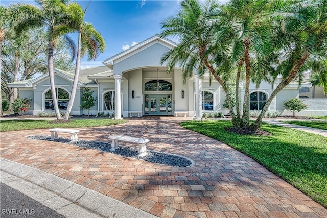 23039 Lone Oak Dr, Estero, FL 33928 - view of front facade featuring french doors, decorative driveway, a front yard, and stucco siding