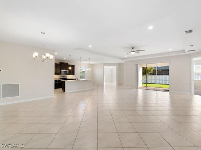2911 SW 25th Pl, Cape Coral, FL 33914 - unfurnished living room with a tray ceiling, a chandelier, ceiling fan, baseboards, and recessed lighting
