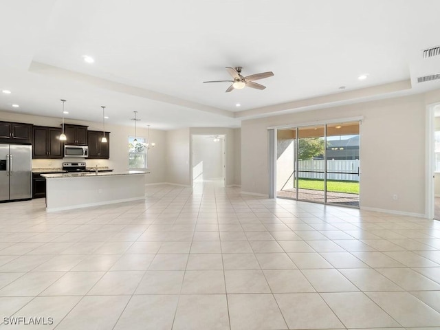 2911 SW 25th Pl, Cape Coral, FL 33914 - unfurnished living room featuring a tray ceiling, a ceiling fan, plenty of natural light, light tile patterned flooring, and recessed lighting