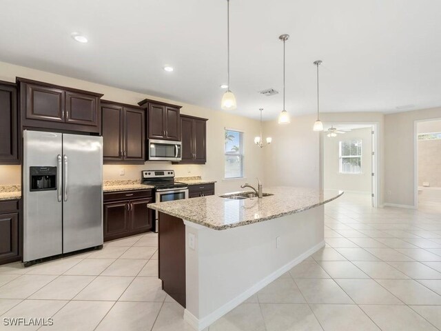 2911 SW 25th Pl, Cape Coral, FL 33914 - kitchen with appliances with stainless steel finishes, a sink, light tile patterned floors, dark brown cabinets, and light stone counters