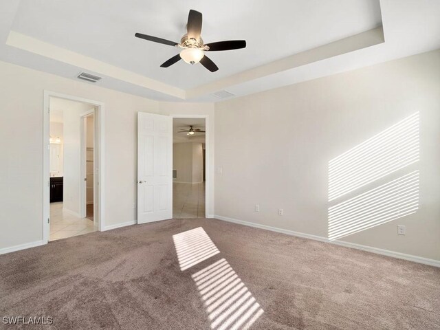 2911 SW 25th Pl, Cape Coral, FL 33914 - unfurnished bedroom featuring a raised ceiling, carpet flooring, baseboards, and a ceiling fan