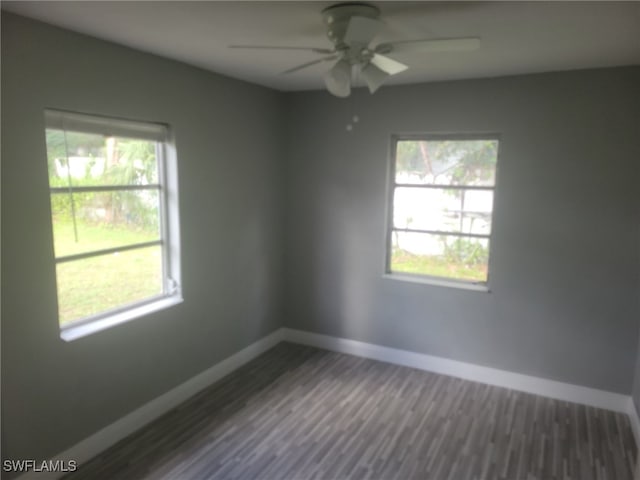 spare room with dark wood-type flooring and ceiling fan