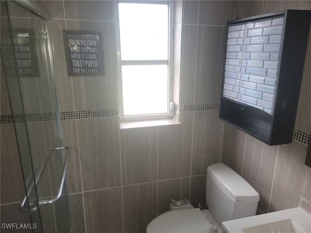 bathroom featuring tile walls, toilet, and walk in shower