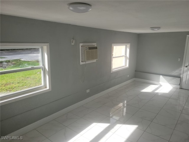 unfurnished room featuring an AC wall unit