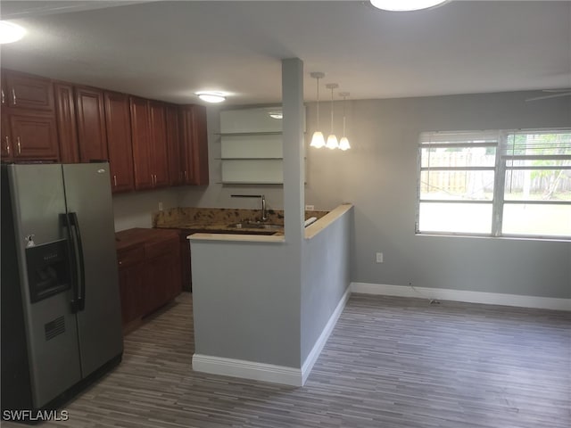 kitchen featuring stainless steel refrigerator with ice dispenser, dark wood-type flooring, sink, and hanging light fixtures