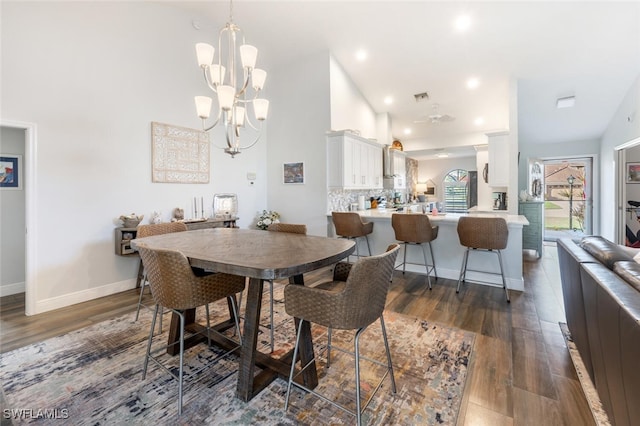5858 Westbourgh Ct, Naples, FL 34112 - dining room featuring high vaulted ceiling, a notable chandelier, baseboards, and dark wood-type flooring