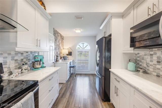 5858 Westbourgh Ct, Naples, FL 34112 - kitchen with white cabinets, light stone counters, wood finished floors, freestanding refrigerator, and black / electric stove