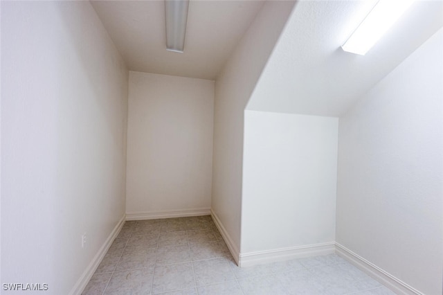 bonus room featuring light tile patterned floors and baseboards