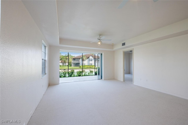 unfurnished room featuring light carpet, ceiling fan, visible vents, and baseboards