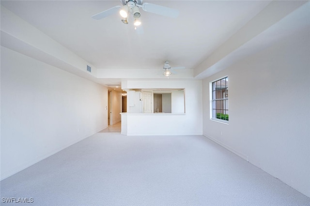 spare room with light carpet, visible vents, and a ceiling fan