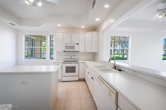 kitchen featuring light countertops, visible vents, white cabinets, a sink, and white appliances