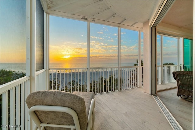 sunroom featuring a water view