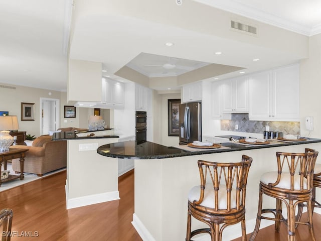 kitchen with stainless steel refrigerator with ice dispenser, white cabinetry, dark hardwood / wood-style flooring, and kitchen peninsula