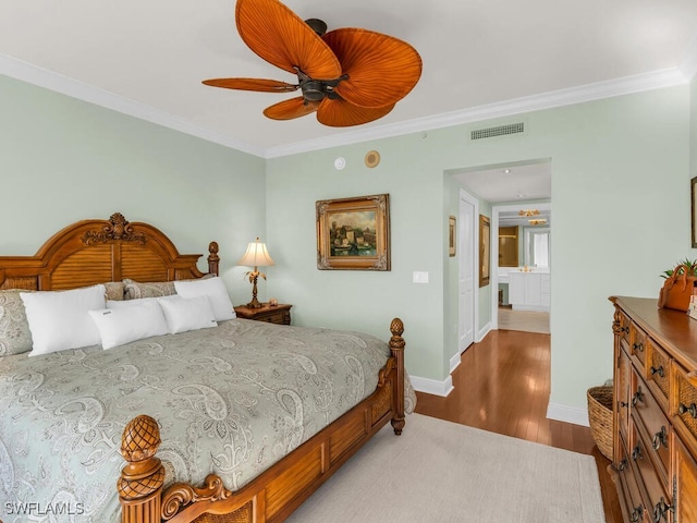 bedroom with hardwood / wood-style flooring, ceiling fan, and ornamental molding