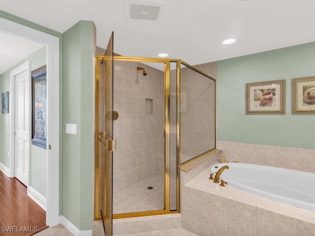 bathroom with hardwood / wood-style flooring and shower with separate bathtub