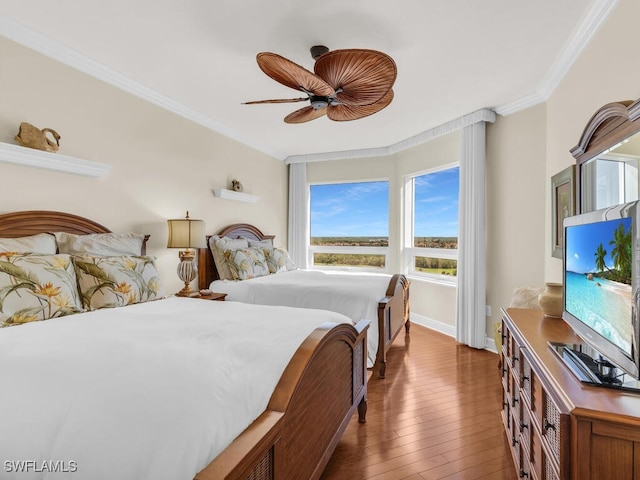 bedroom featuring crown molding, ceiling fan, and dark hardwood / wood-style floors