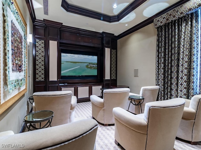 cinema featuring a tray ceiling and ornamental molding