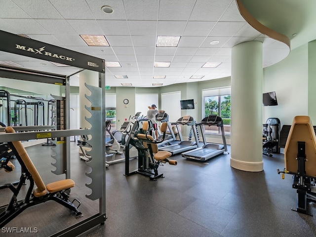 workout area with a paneled ceiling and ornate columns