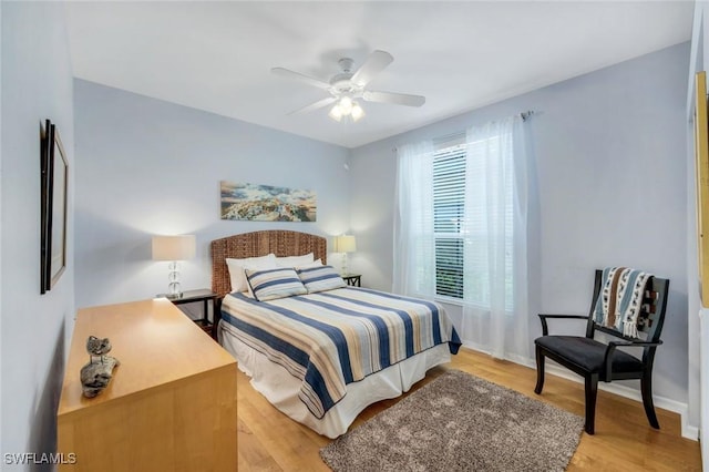 bedroom with baseboards, a ceiling fan, and light wood finished floors