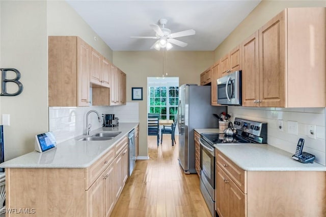 77 Silver Oaks Cir Unit 8-104, Naples, FL 34119 - kitchen featuring appliances with stainless steel finishes, a sink, light brown cabinets, a ceiling fan, and backsplash