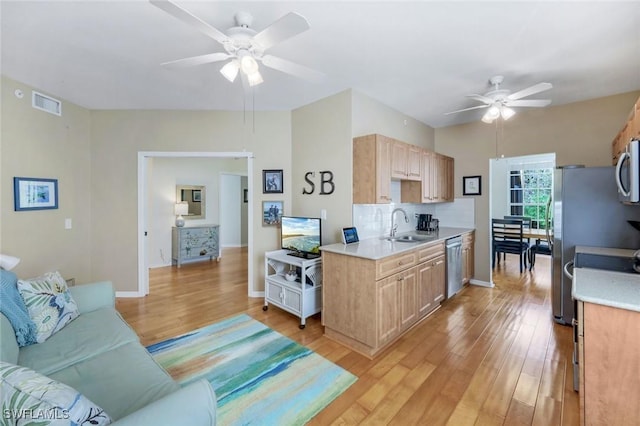 kitchen featuring visible vents, light brown cabinetry, light countertops, stainless steel appliances, and a sink