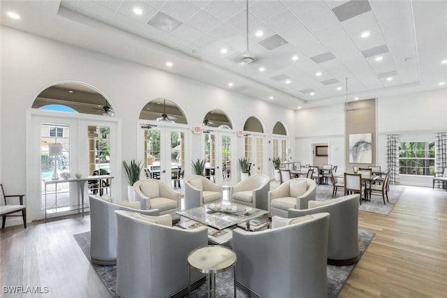 77 Silver Oaks Cir Unit 8-104, Naples, FL 34119 - living room featuring french doors, a towering ceiling, and wood finished floors