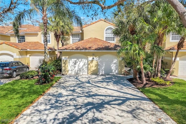 mediterranean / spanish house featuring a tile roof, a garage, a front yard, and stucco siding