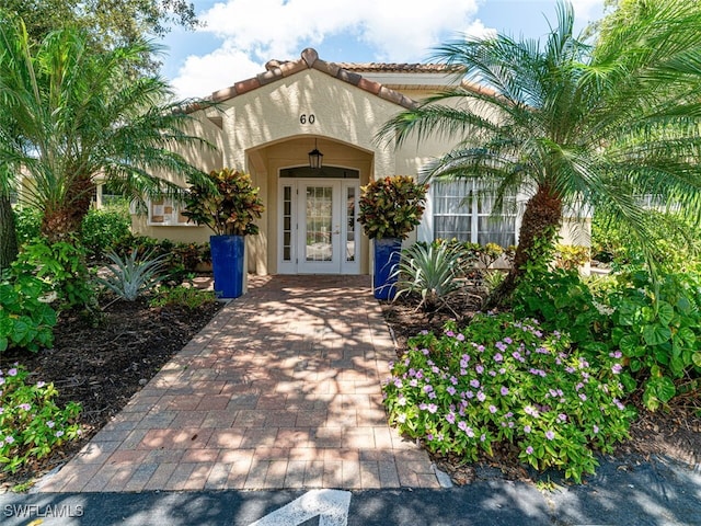 property entrance with a tiled roof and stucco siding