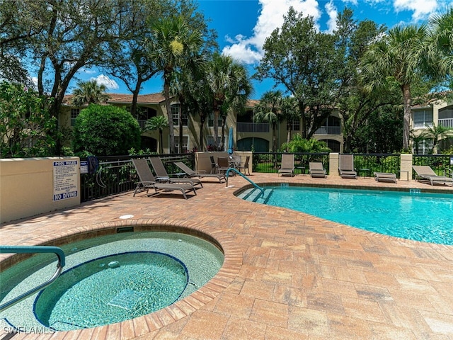 pool featuring a patio, a community hot tub, and fence