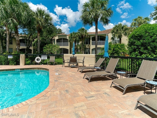 community pool featuring a patio area and fence